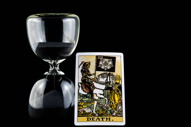 istock Hourglass with Death Tarot Card Isolated on a Black Background 1438185063