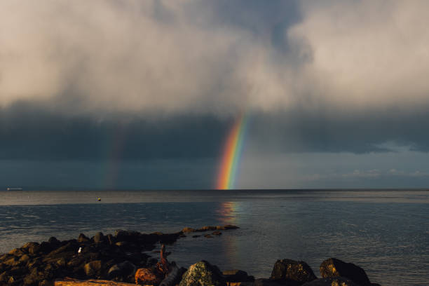 istock gray clouds with rainbow over the ocean 1438185334