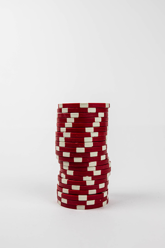 a vertical shot of red poker chips over white background