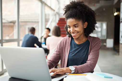 Black girl, college student and study, education and laptop for research on writing assignment or studying for class. Young, smile and university, search on internet and ideas in notebook with tech.