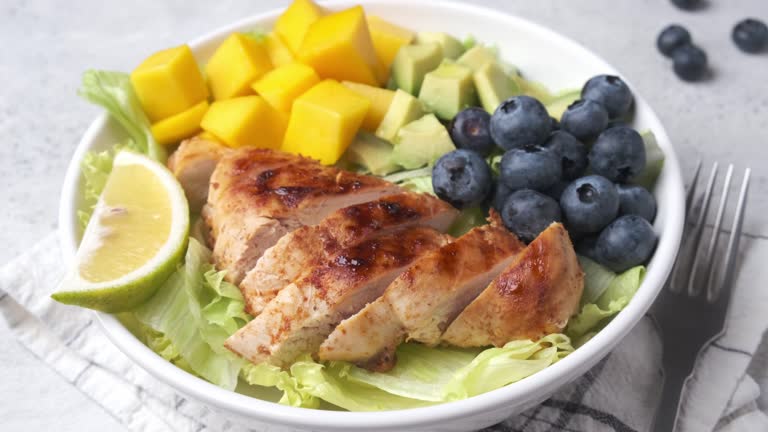 Grilled chicken breast salad with mango, avocado and blueberries.