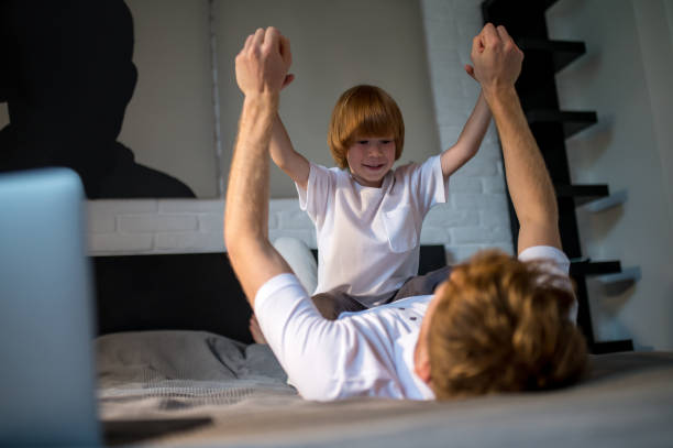 istock Dad and son spending time together in bed before going to sleep 1438189500