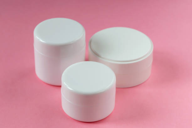 istock Three white cosmetic jars on a pink background 1438189688