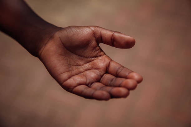 A small child sits on a sidewalk in Rwanda, Africa.