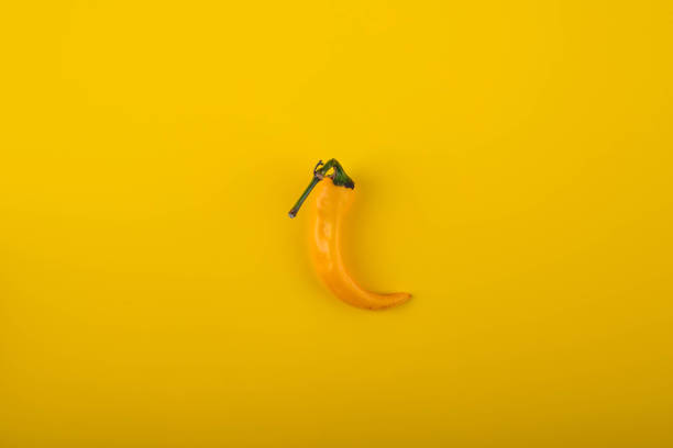 istock Hot chilli pepeper on yellow background. 1438191078