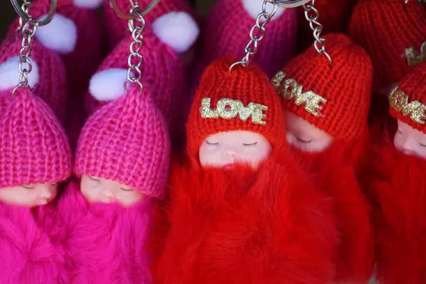 miniature baby doll sleeping sweet with winter hat and text love on it.