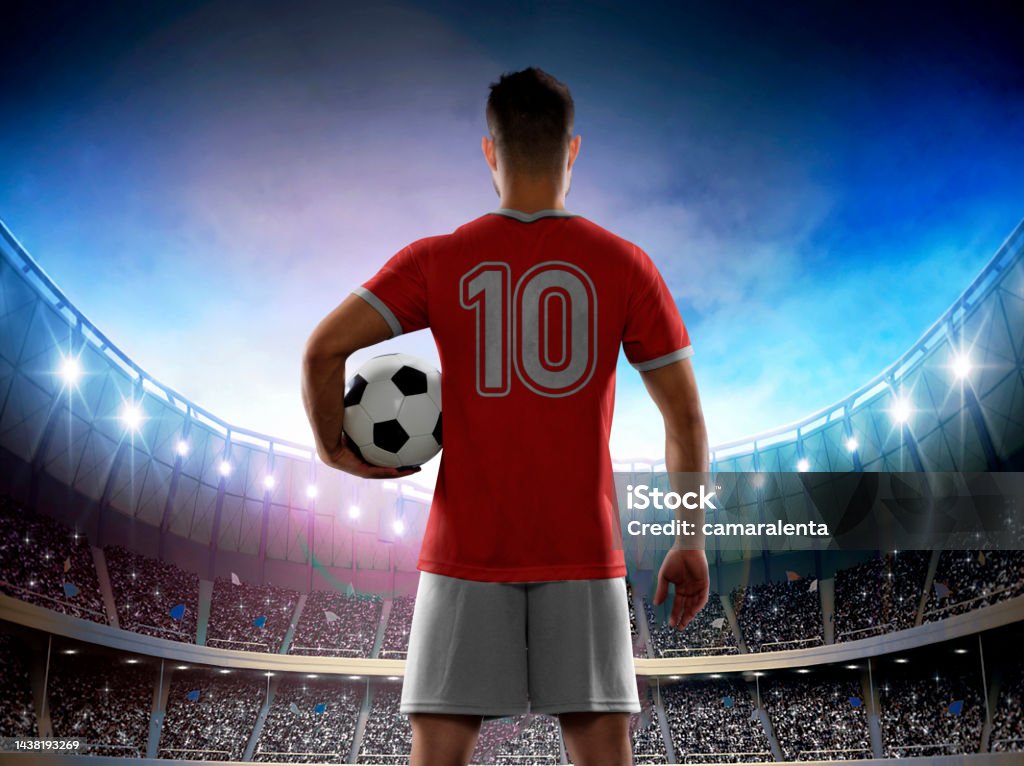 Male professional soccer player with national team jersey entering the stadium. Male professional soccer player wearing an Switzerland national red team jersey with the number ten on the back entering the stadium full of fans for a match. 2022 Stock Photo