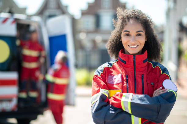 istock Paramedic posing for the camera with colleagues on the background 1438194883