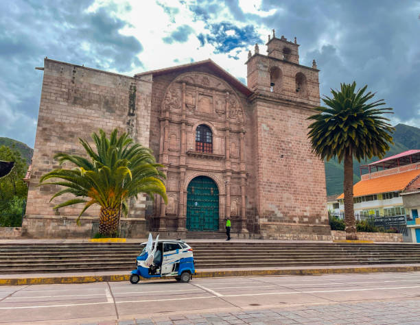 Urubamba, Peru, march 2022: - view of Iglesia San Pedro - Church made of  red sandstone, in Plaza de Armas,  town square of Urubamba -  a town in the Sacred Valley region of Peru.