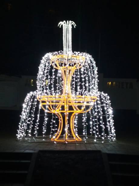 公園内の花輪ランプで作られた軽いクリスマスフィギュアキャリッジスノーマン噴水。お祝いの新年のアトムスフィア - phantasmagoria ストックフォトと画像
