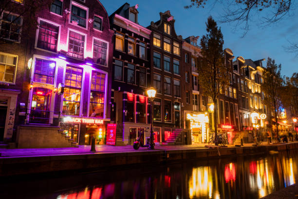 De Wallen red light street with nylon signs and shops in the city center on the canal at night Netherlands Amsterdam October 28, 2022, De Wallen red light street with nylon signs and shops in the city center on the canal at night wellen stock pictures, royalty-free photos & images