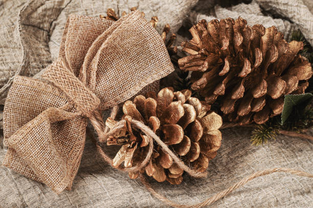 istock Christmas tree cones and Burlap eco decor, bow. Handmade gift, craft rustic style. New Year, Christmas 1438198267