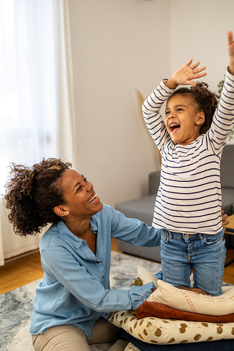 Mother and daughter dancing in the living room