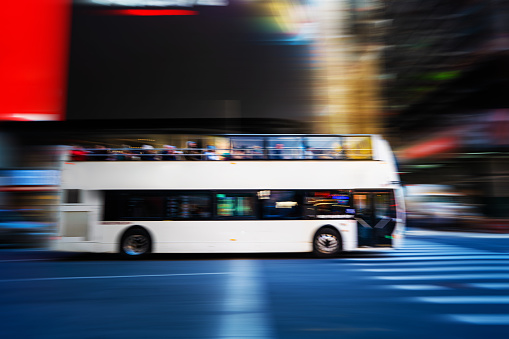 White double decker bus with tourists in Manhattan around Times Square area