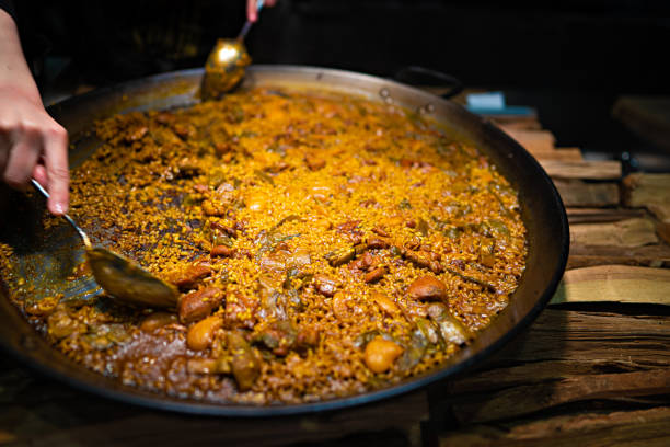 Servindo uma porção da paella tradicional de Valência - foto de acervo