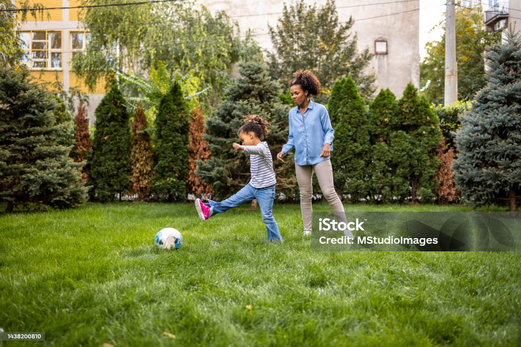Mother and daughter are playing with a ball outdoors Mother and daughter having fun outdoors, they are enjoying Daughter Stock Photo