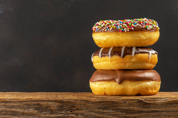 istock Delicious donuts on rustic wooden table. Food concept. 1438203793