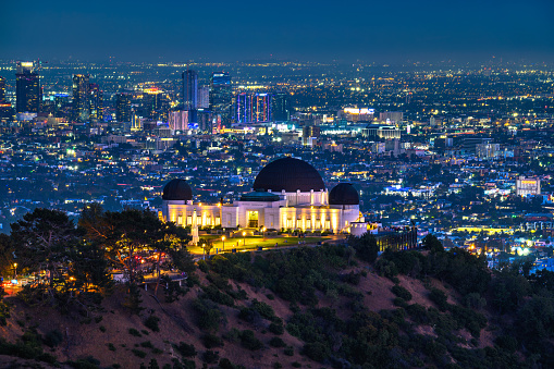 Los Angeles, California, USA - June 14, 2022 : Griffith Observatory and Los Angeles skyline photographed from Griffith Park at night.