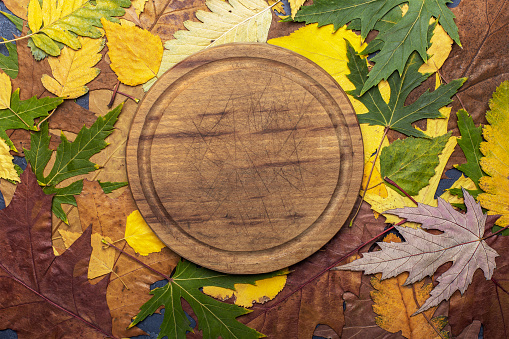 wooden cutting board for groceries on autumn background