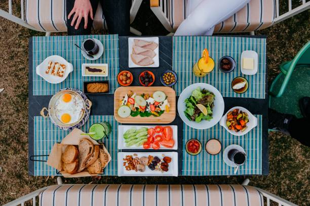 istock Top view of a breakfast table with scrambled eggs, sausages, nuts, salads and tea 1438207523