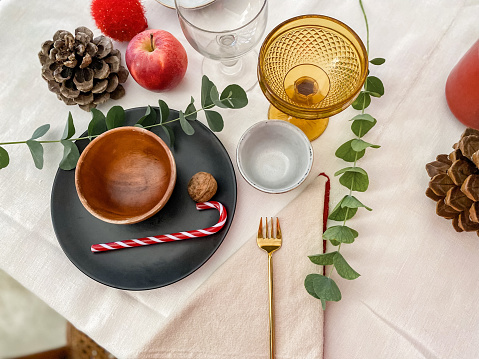 Cozy Christmas table set at home with natural elements and candy cane