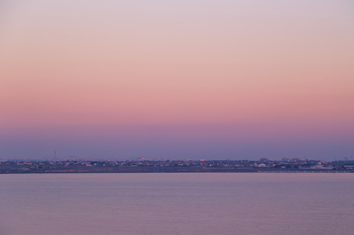 Stunning pink sunset over the lake, sunset background. Khadzhibey Estuary near to the city Odesa, Ukraine.