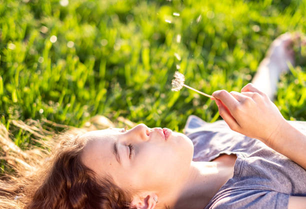 istock a little girl blows a flower 1438209713