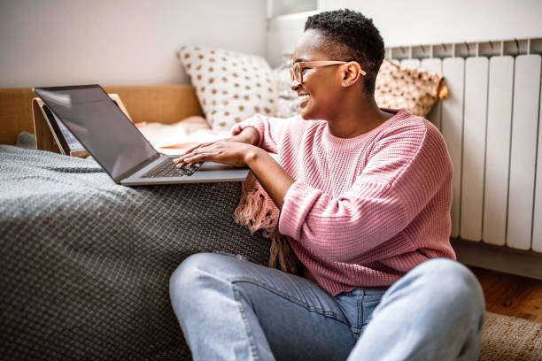 istock Woman using laptop at home while sitting on floor 1438210589