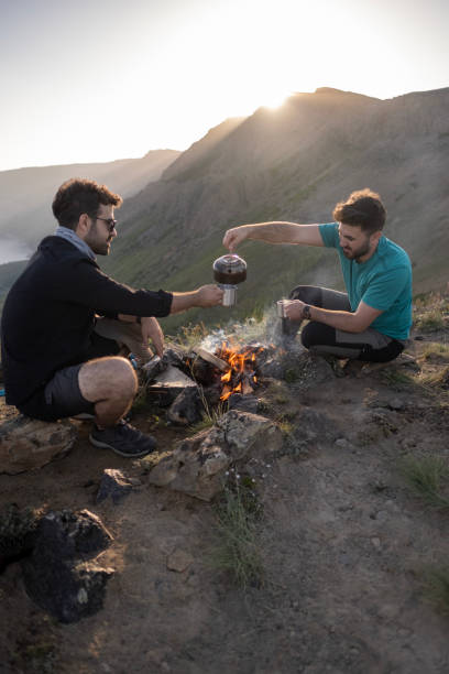 istock Hands of hikers cheering up with camping cups 1438210988