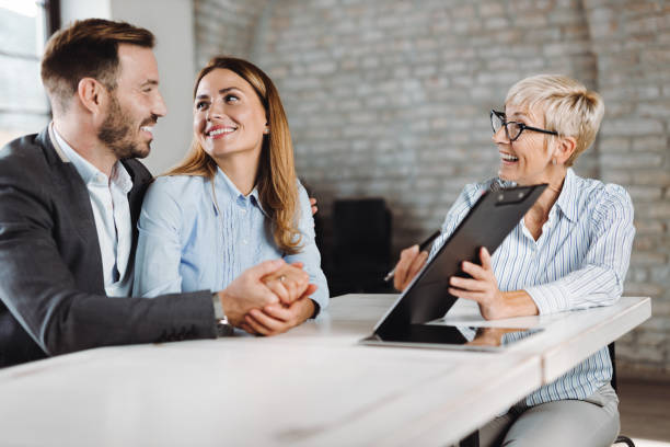 istock Happy couple talking with insurance agent on a meeting 1438211178
