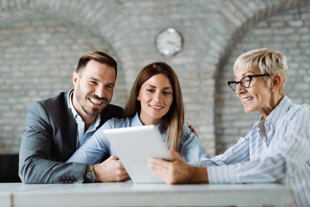istock Happy couple talking with insurance agent on a meeting 1438211291