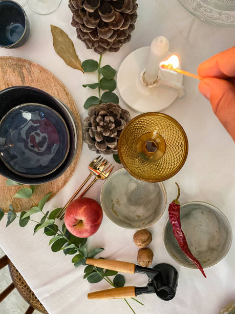 istock Hand lighting a candle from the cozy Christmas table at home 1438212021