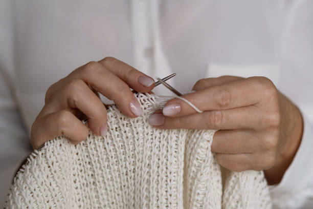 istock Woman's hands knitting white wool yarn pattern. Freelance creative handicraft concept, hobby and lifestyle 1438212025