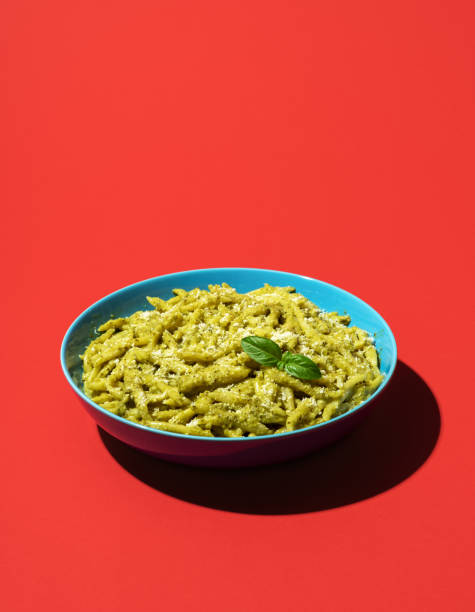 istock Pasta with pesto minimalist on a red background 1438212310