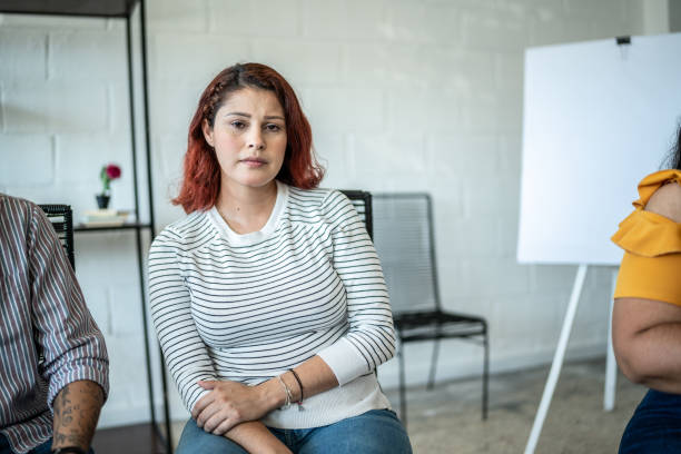 Portrait of sad mid adult woman during a group therapy stock photo