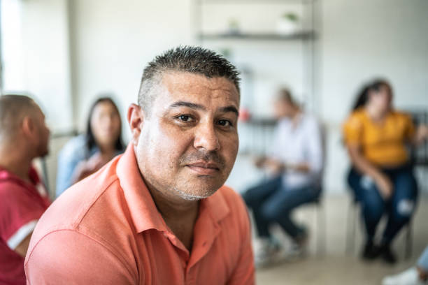 Portrait of mid adult man during a group therapy at mental health center Portrait of mid adult man during a group therapy at mental health center hispanic guy stock pictures, royalty-free photos & images