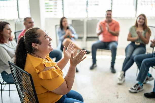 mid adult frau applaudiert während einer präsentation - training business seminar clapping stock-fotos und bilder