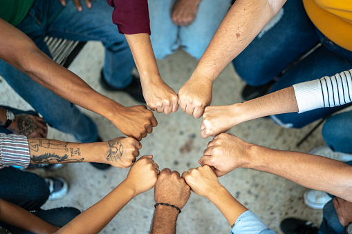 High angle view of happy crowd with their hands raised an looking at the camera. Two of them are in a wheelchair. Isolated on white.