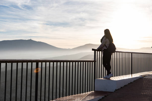 istock Beautiful women standing at a viewpoint on a cliff during sunset 1438226292
