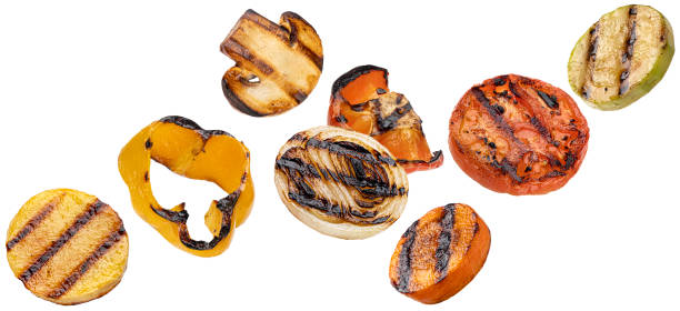 Falling grilled vegetable slices isolated on white background