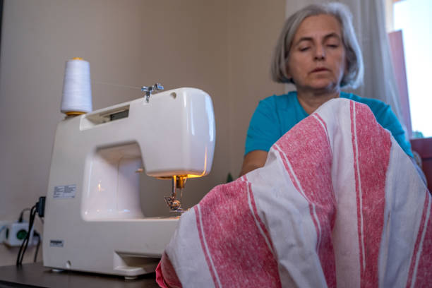 istock White-haired woman sewing with machine at home 1438229687