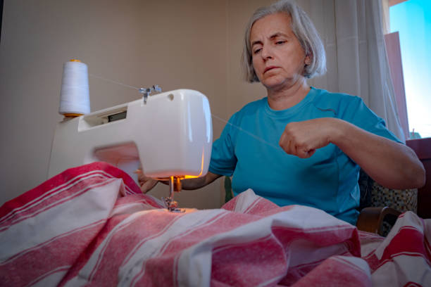 istock White-haired woman sewing with machine at home 1438230990