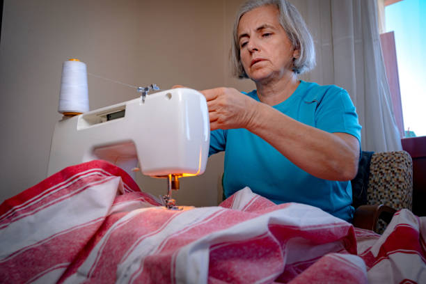 istock White-haired woman sewing with machine at home 1438230994