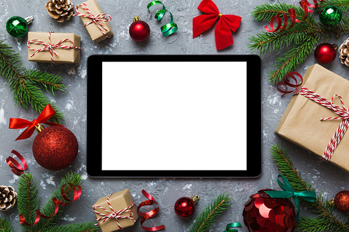 Digital tablet mock up with rustic Christmas decorations for app presentation top view with empty space for you design. Christmas online shopping concept. Tablet with copy space on colored background.
