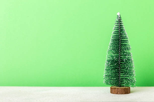 istock One small Christmas tree on colored background. new year decoration with copy space 1438231106