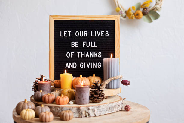 Felt letter board and text let our lives be full of thanks and giving Felt letter board and text let our lives be full of thanks and giving. Autumn table decoration. Interior decor for thanksgiving and fall holidays with handmade pumpkins and candles thanksgiving full stock pictures, royalty-free photos & images