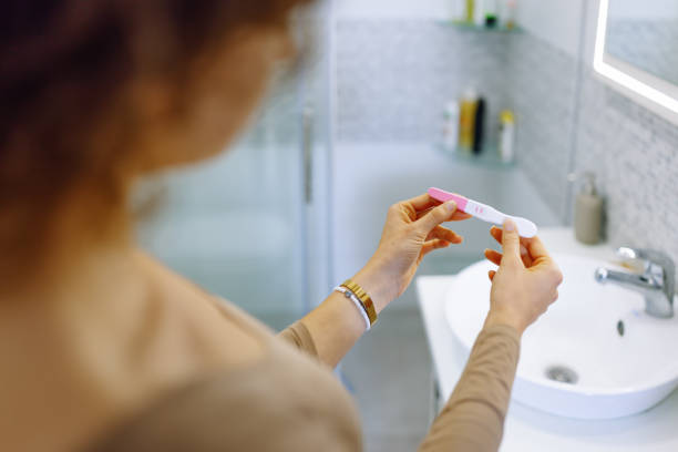 istock Unrecognizable woman in bathroom holding a pregnancy test 1438236262