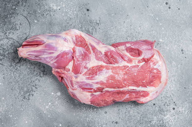 Raw lamb shoulder meat on butcher table. Gray background. Top view