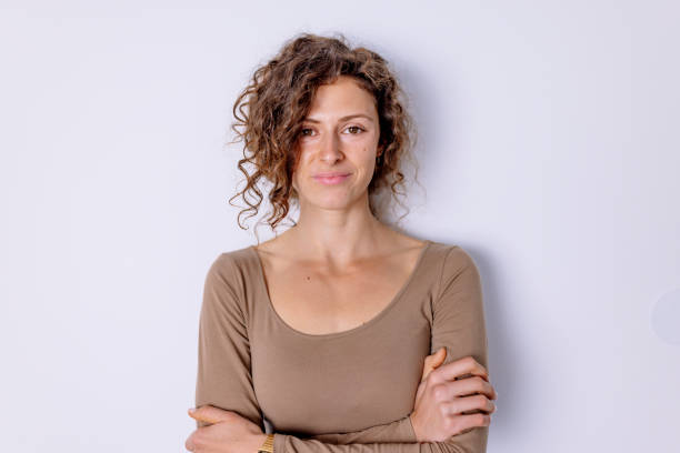 istock Adorable curly woman posing with crossed arms 1438238497