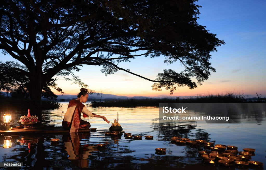 Asia woman in Thai dress traditional hold kratong and bring Krathong to float in Loi kratong day of Thailand. Loi Krathong Traditional Festival held every November to pray respect to Water Goddess Loi Krathong Stock Photo